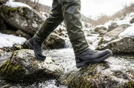 岩から岩へ渓流を渡り歩く、ウェーダー着用のアングラー画像